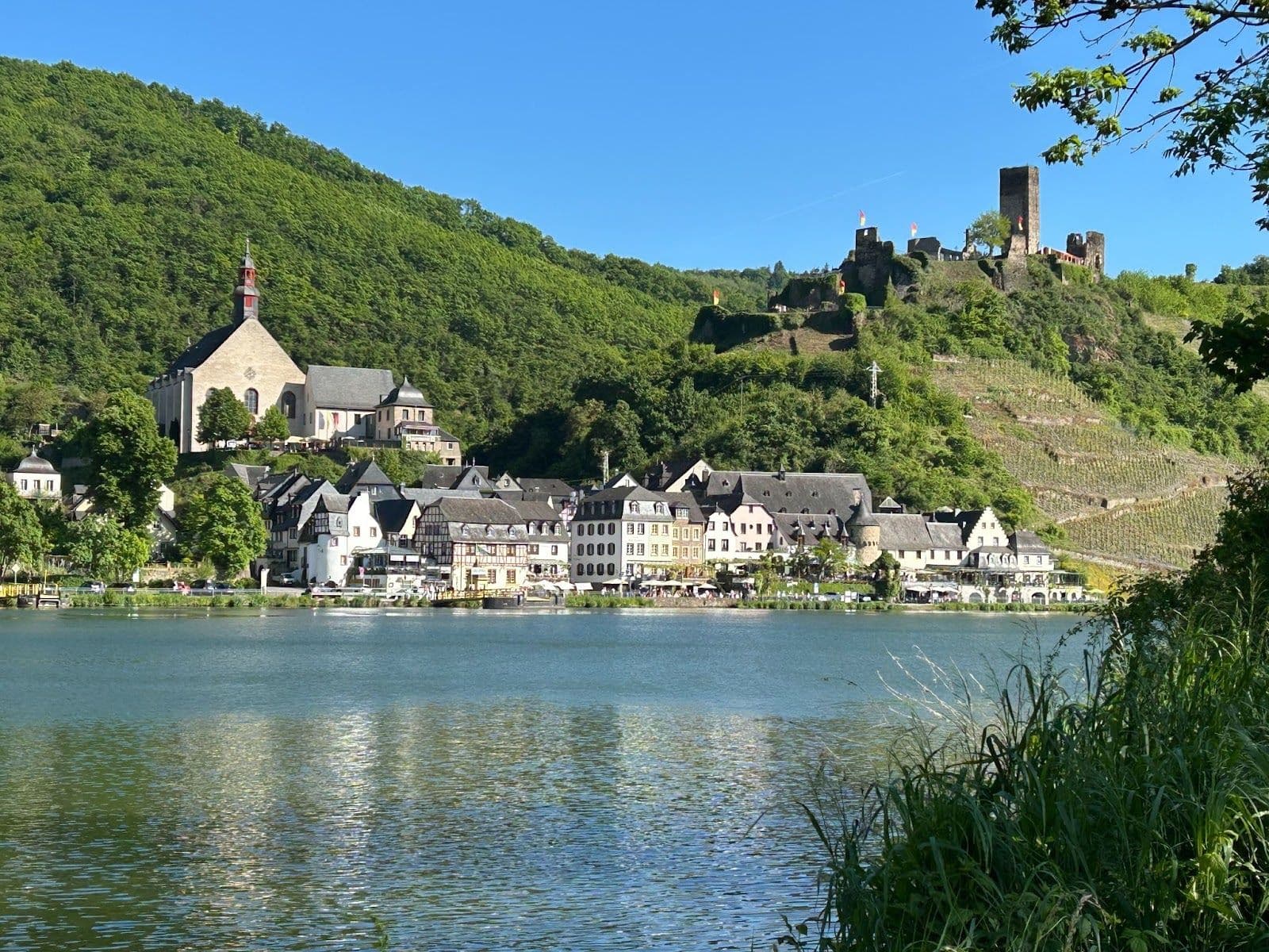 A castle on the hill and old buildings below along a river