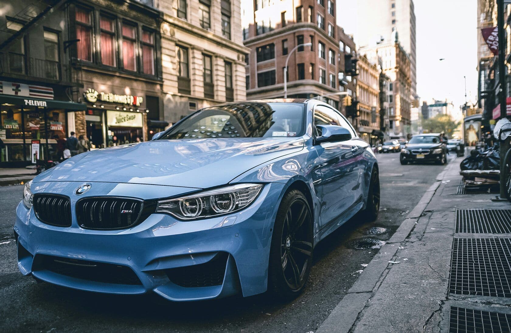 Light blue BMW parked on a city street