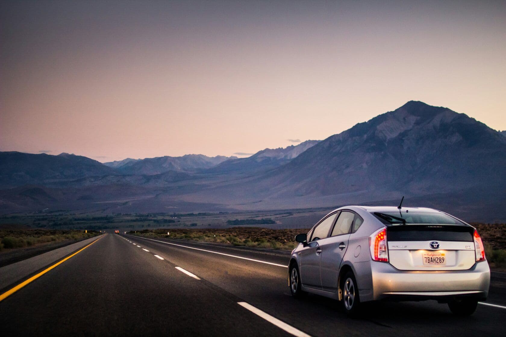 A Toyota on the road at dusk in the mountains