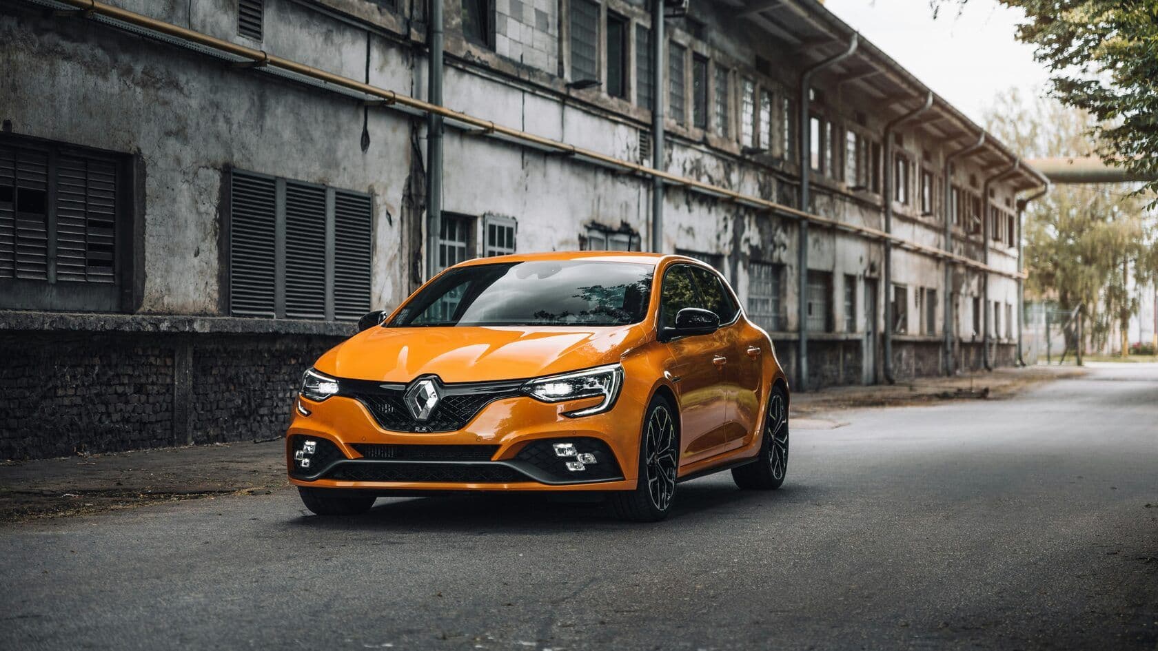 An orange Renault on a city street