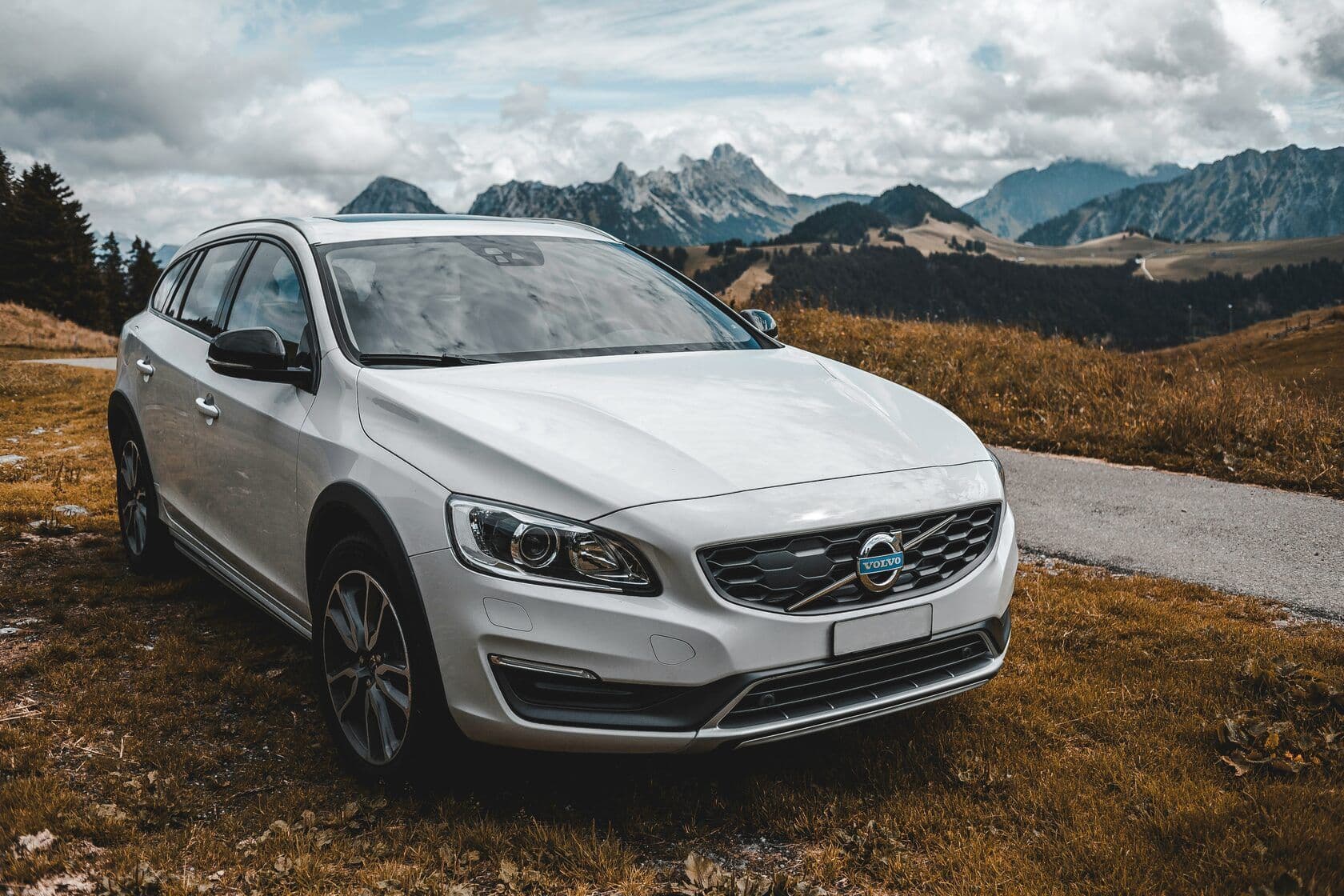 A Volvo parked along a small road in the mountains