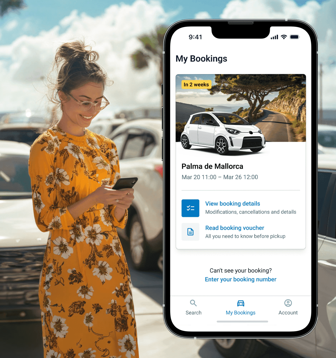 Uma mulher a olhar para o telemóvel num parque de estacionamento